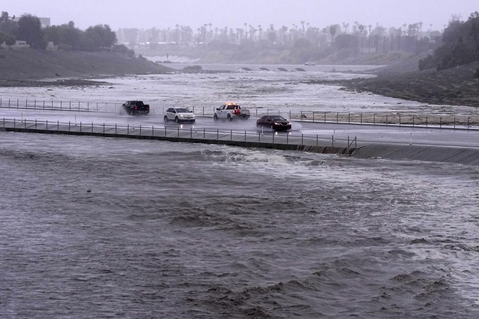 Vehicles cross over a flood control basin that has almost reached the street, Sunday in Palm Desert, Calif. Forecasters said Tropical Storm Hilary was the first tropical storm to hit Southern California in 84 years.
