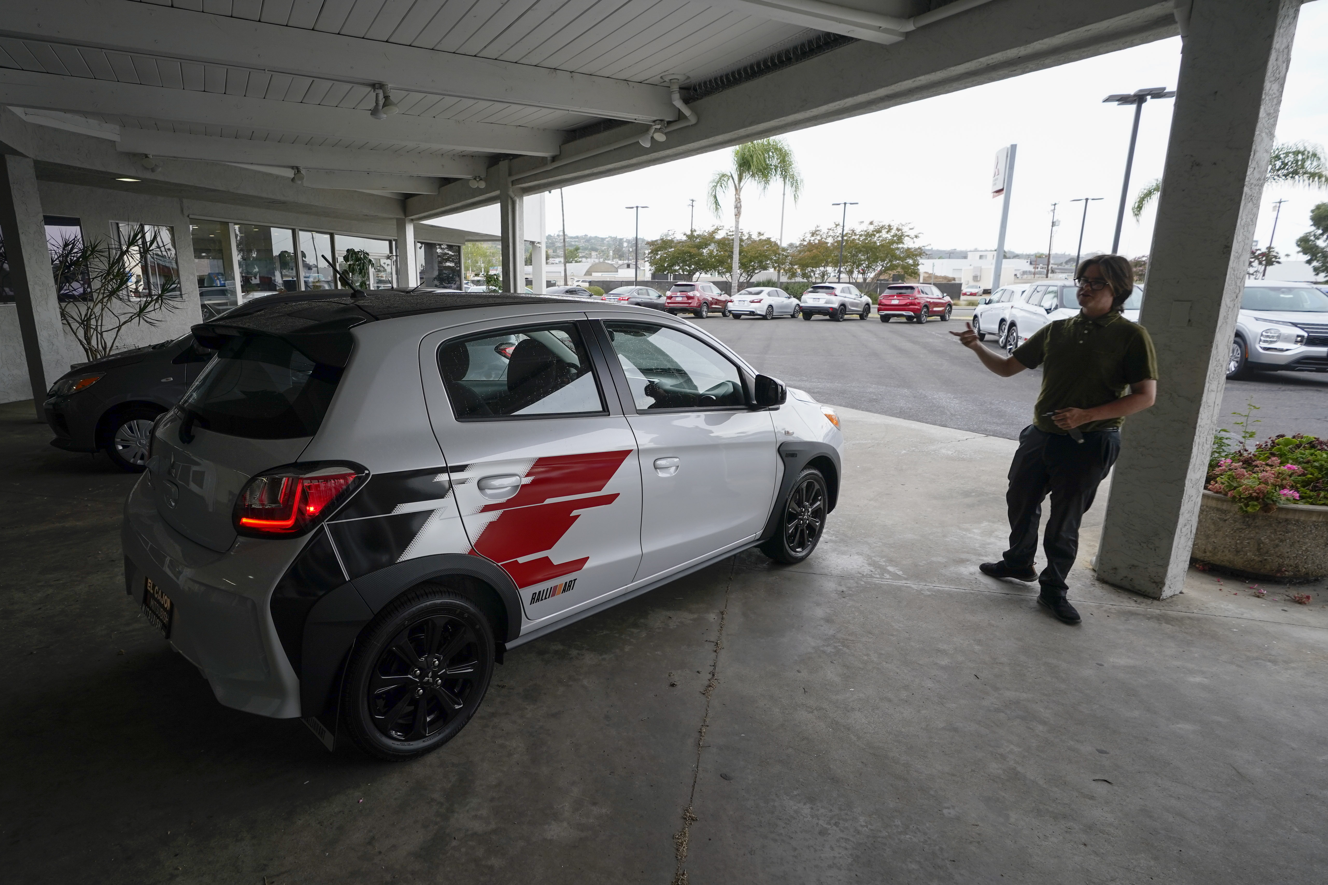 Mitsubishi salesman Matthew Boston points to a new Mitsubishi Mirage for sale at El Cajon Mitsubishi Aug. 8,  in El Cajon, Calif. At a time when auto buyers increasingly want pricey SUVs and trucks and fewer want small cars, the Mirage remains the lone new vehicle whose average sale price is under 20 grand.