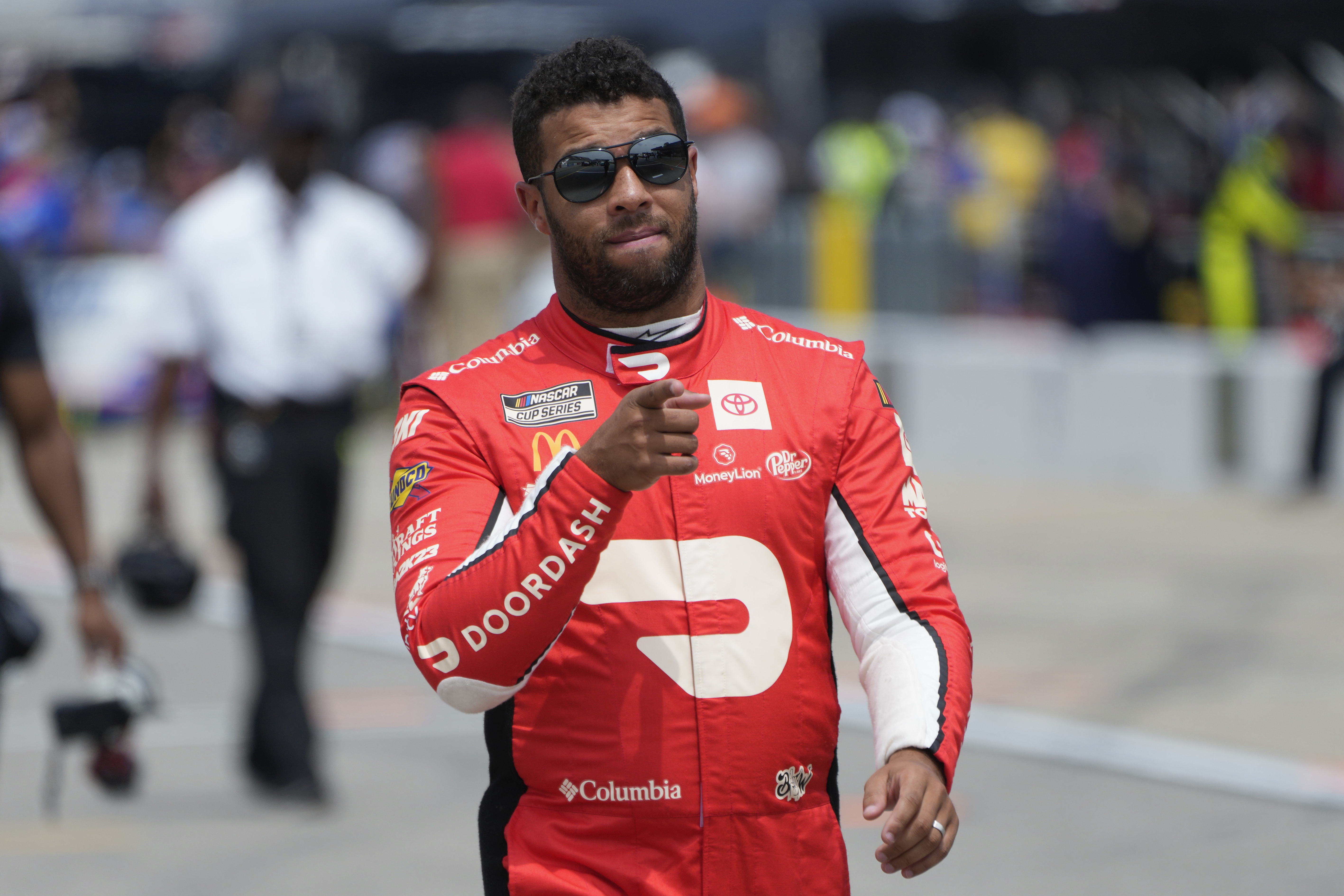 Bubba Wallace walks to his car during qualifications for a NASCAR Cup Series auto race at Michigan International Speedway in Brooklyn, Mich., Saturday, Aug. 5, 2023. 