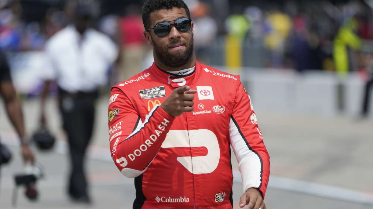 Bubba Wallace walks to his car during qualifications for a NASCAR Cup Series auto race at Michigan International Speedway in Brooklyn, Mich., Saturday, Aug. 5, 2023.