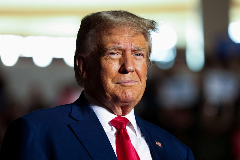 Former President and Republican presidential candidate Donald Trump looks on as he holds a campaign rally in Erie, Pa, July 29. Trump plans to turn himself in Thursday in connection with his Georgia indictment.