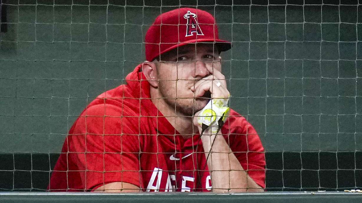 Los Angeles Angels' Mike Trout watches from the dugout during the ninth inning of the team's baseball game against the Houston Astros, Friday, Aug. 11, 2023, in Houston.