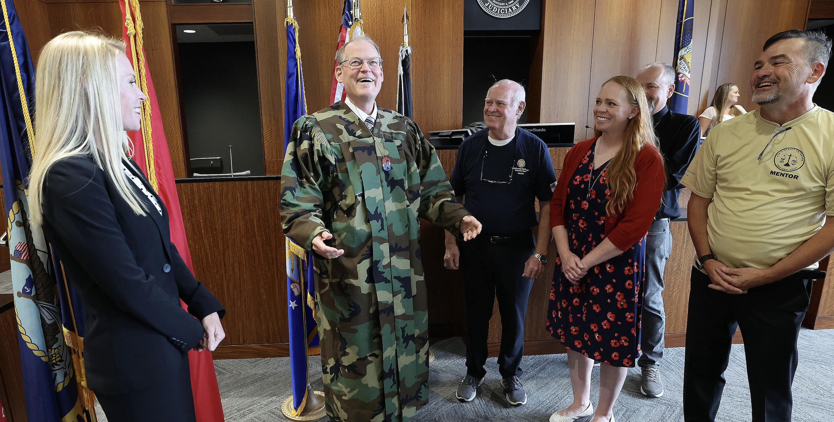 Judge Kraig Powell smiles after receiving a camouflage robe given to him in his courtroom at the Provo District Courthouse in Provo on Tuesday. The robe signifies his contribution to the local veteran community.