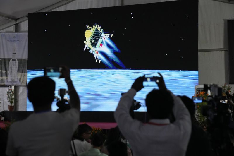 Journalists film the live telecast of spacecraft Chandrayaan-3 landing on the moon at ISRO's Telemetry, Tracking and Command Network facility in Bengaluru, India, Wednesday. India lands a spacecraft near the moon’s south pole, becoming the fourth country to touch down on the lunar surface.