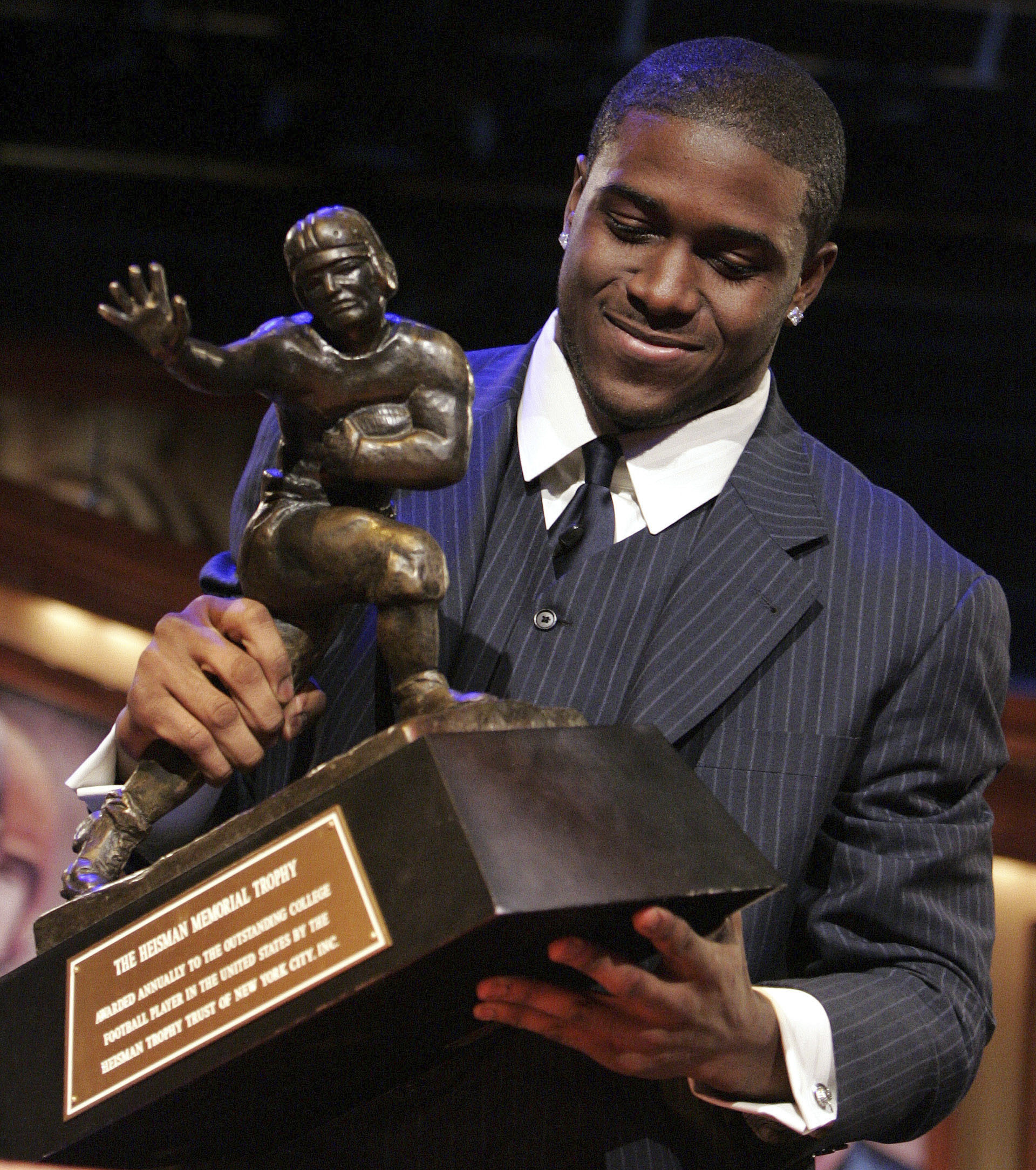 FILE - Southern California tailback Reggie Bush picks up the Heisman Trophy after being announced as the winner of the award Saturday, Dec. 10, 2005, in New York. Former Southern California running back Reggie Bush plans to file a defamation lawsuit against the NCAA over a statement made by college sports' governing body about the reasoning for its decision not to restore the Heisman Trophy winner's records. Bush announced his plan Wednesday, Aug. 23, 2023, through his attorneys at McCathern PLLC.