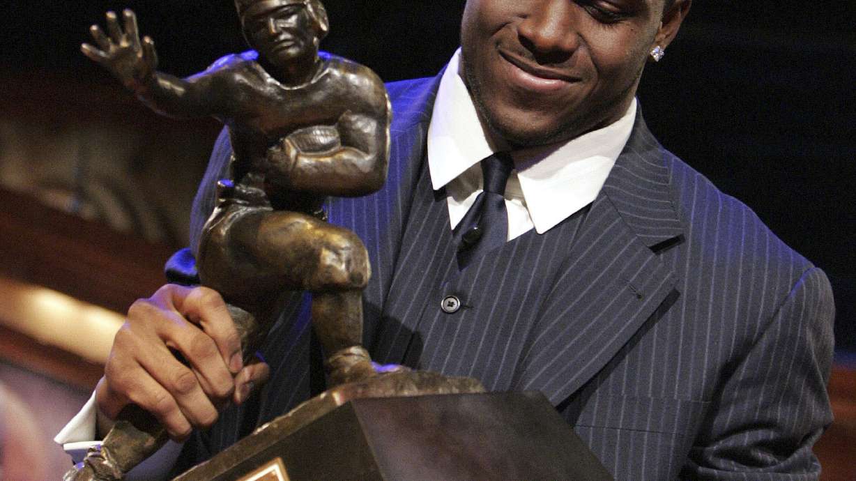 FILE - Southern California tailback Reggie Bush picks up the Heisman Trophy after being announced as the winner of the award Saturday, Dec. 10, 2005, in New York. Former Southern California running back Reggie Bush plans to file a defamation lawsuit against the NCAA over a statement made by college sports' governing body about the reasoning for its decision not to restore the Heisman Trophy winner's records. Bush announced his plan Wednesday, Aug. 23, 2023, through his attorneys at McCathern PLLC.