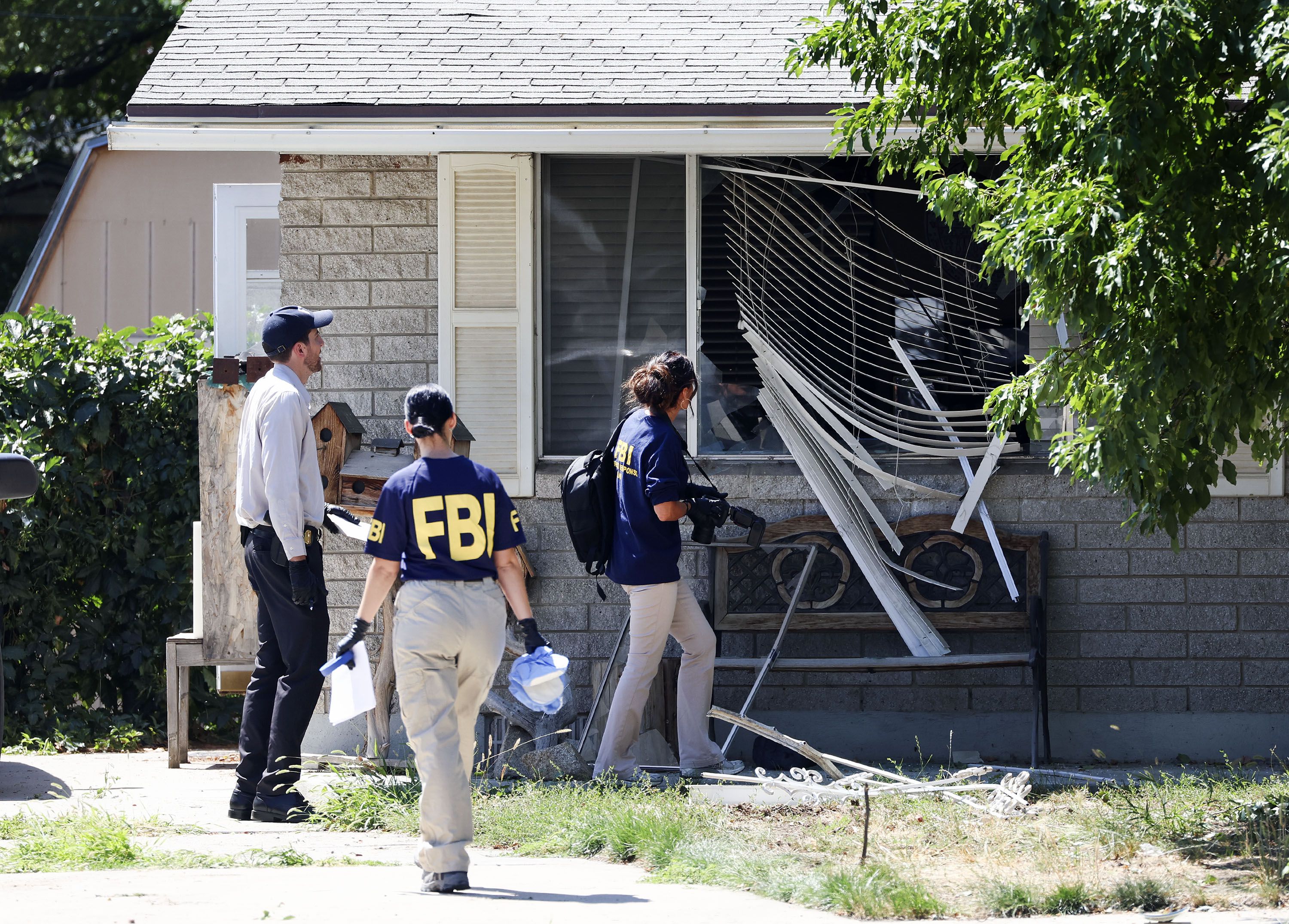 Law enforcement agents investigate at the home of Craig Robertson, who was shot and killed by FBI agents, in Provo on Aug. 9. The Utah County Attorney's Office announced Friday they have been investigating the shooting.