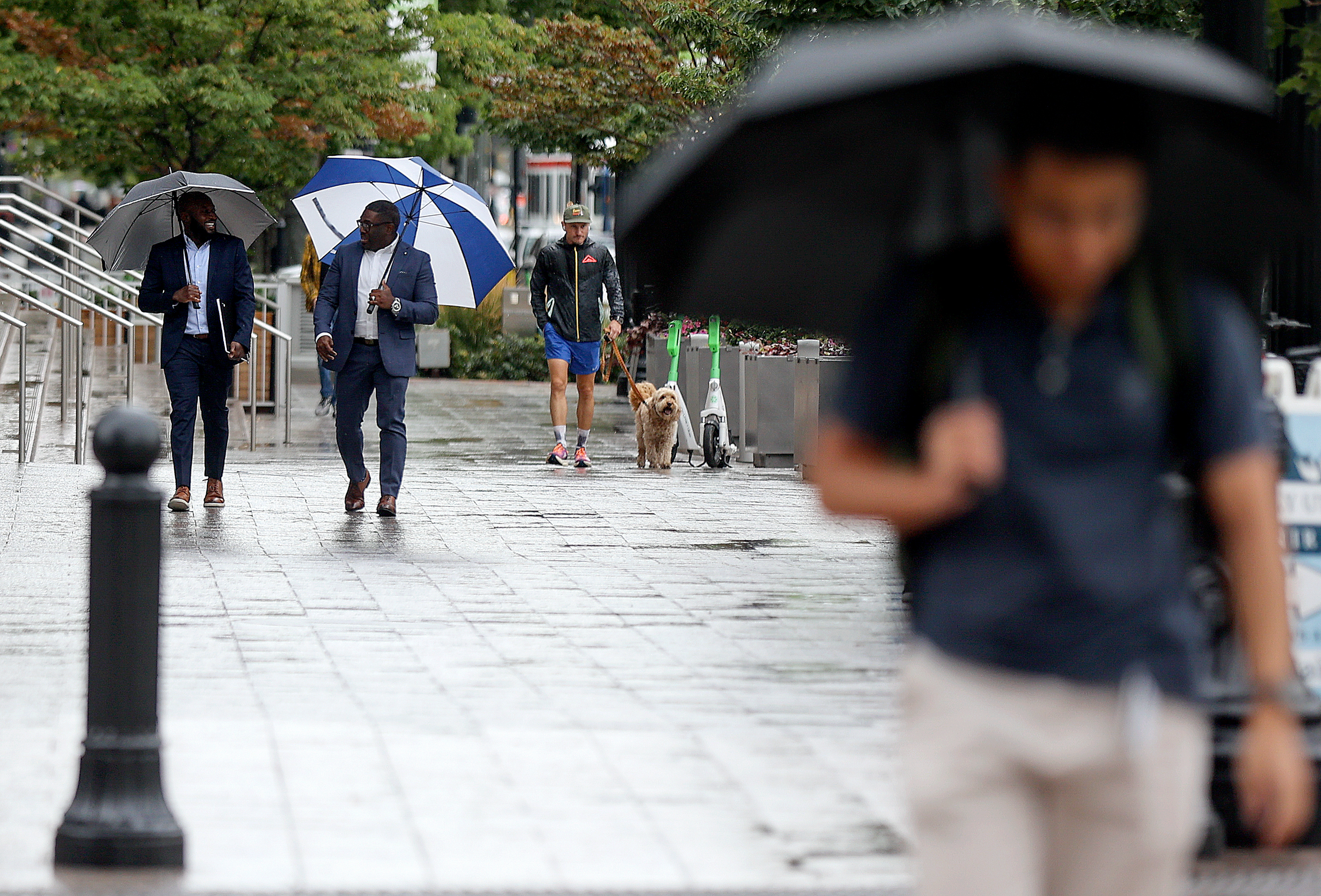 People walk in the rain in downtown Salt Lake City on Tuesday. More rain is in Utah's forecast Thursday and Friday, aided by the remnants of Tropical Storm Harold.