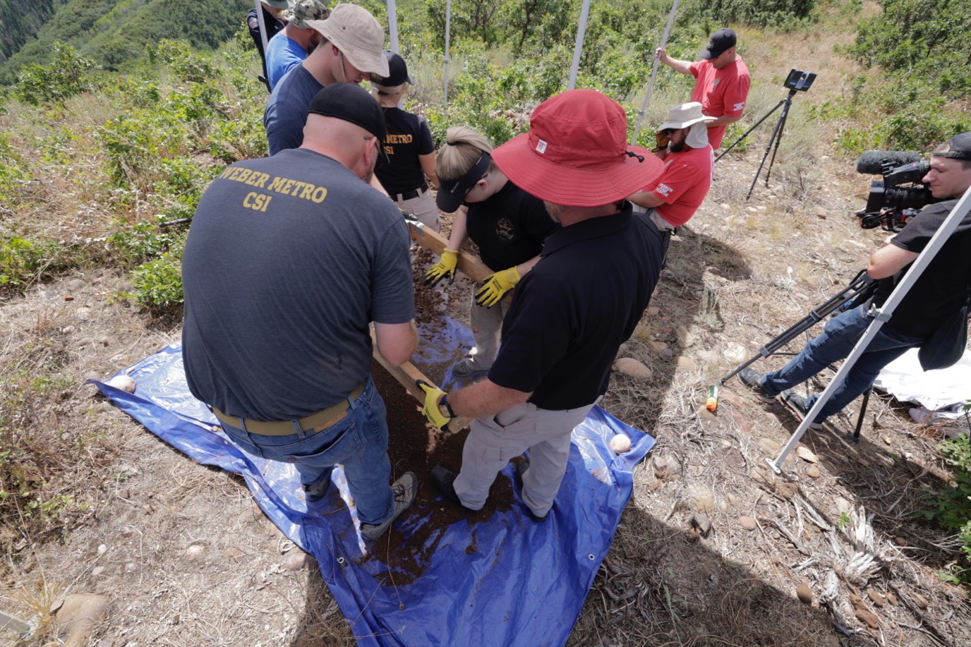Law enforcement investigators exhume a possible burial site in the area of Causey Reservoir Reservoir on Wednesday as part of a cold case investigation.