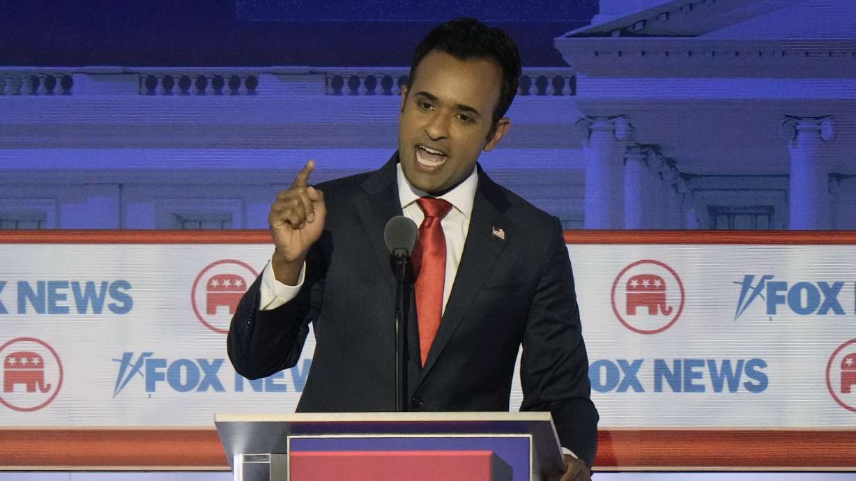 Vivek Ramaswamy speaks at a Republican presidential primary debate Wednesday in Milwaukee. He called climate change a "hoax." Sen. Mitt Romney, R-Utah, said it's an issue the GOP needs to take more seriously.