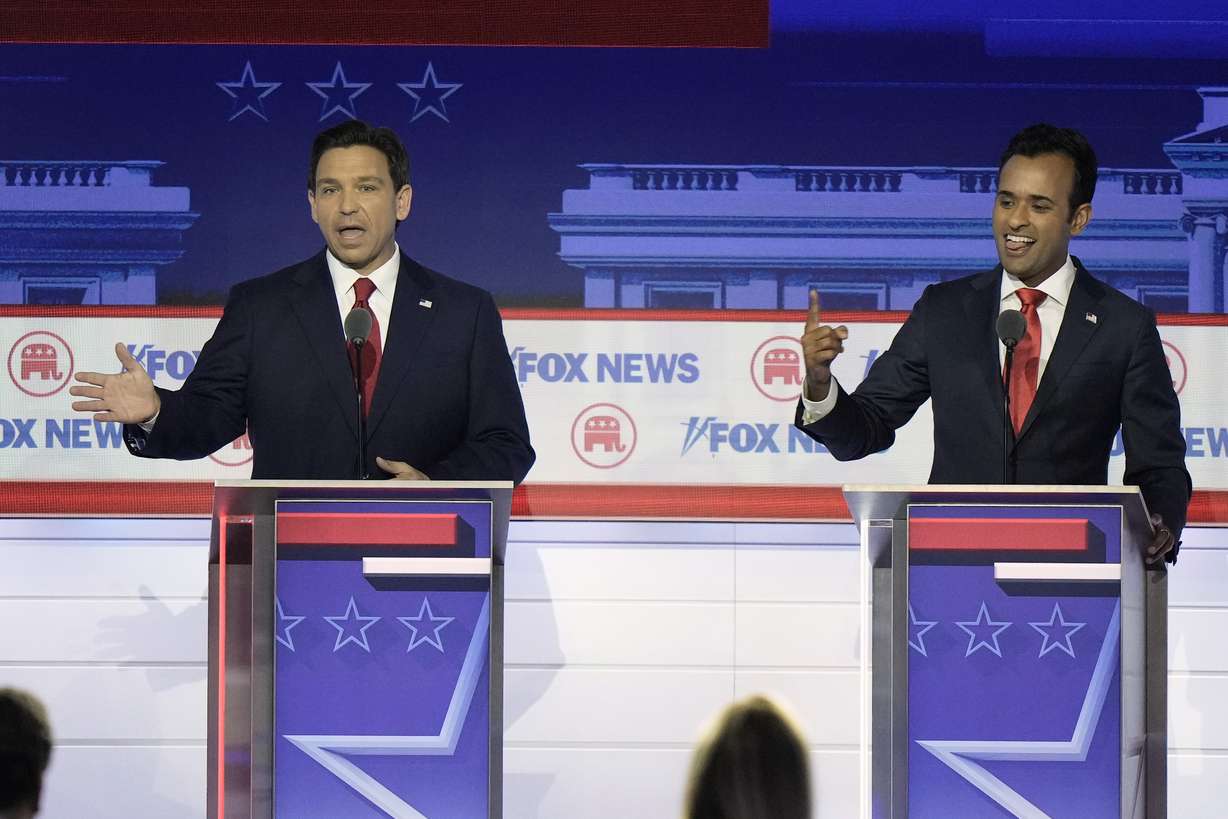 Florida Gov. Ron DeSantis and businessman Vivek Ramaswamy speak at the same time during a Republican presidential primary debate hosted by Fox News on Wednesday in Milwaukee.