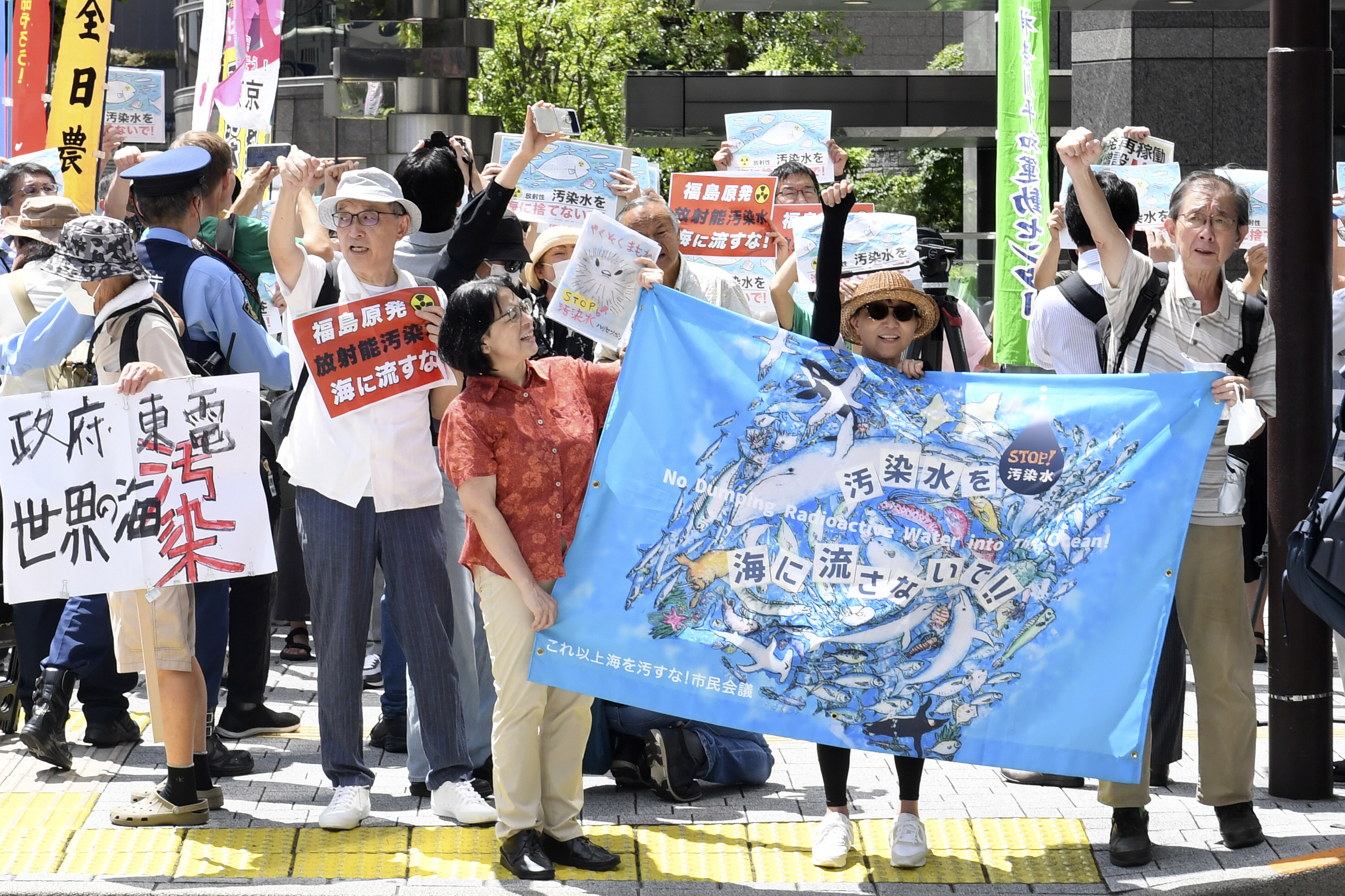 Protester holds a sign during a rally against the treated radioactive water release from the damaged Fukushima nuclear power plant, in front of Tokyo Electric Power Company Holdings  headquarters, Thursday, in Tokyo. The plant will begin releasing the first batch of treated and diluted radioactive wastewater into the Pacific Ocean Thursday, utility executives said.