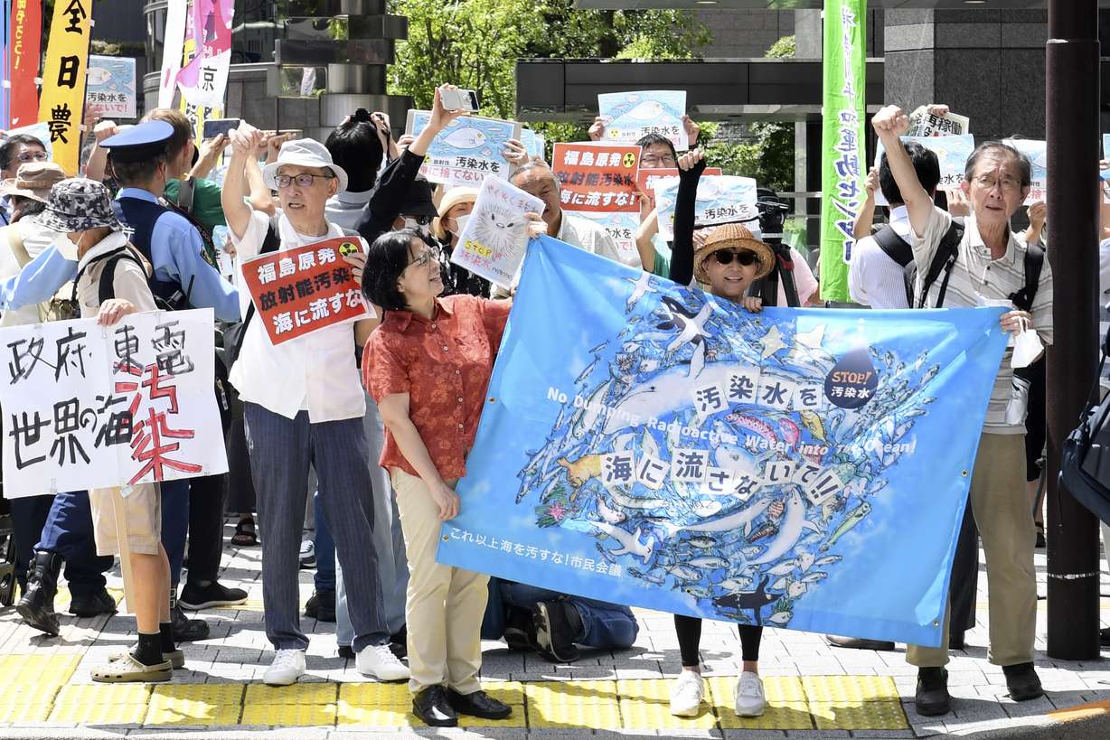 Protester holds a sign during a rally against the treated radioactive water release from the damaged Fukushima nuclear power plant, in front of Tokyo Electric Power Company Holdings headquarters, Thursday, in Tokyo. The plant will begin releasing the first batch of treated and diluted radioactive wastewater into the Pacific Ocean Thursday, utility executives said.