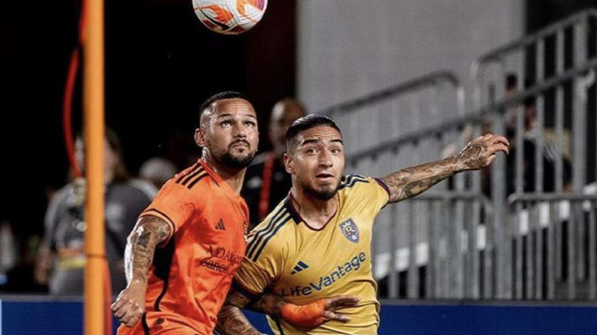 Chicho Arango wrestles with a Dynamo player in Houston.