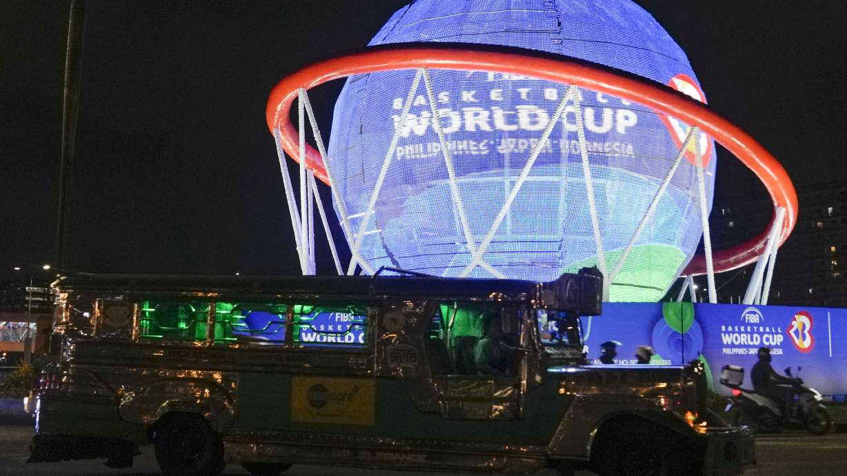 A vehicle passes a giant FIBA Basketball World Cup themed display near one of the venues at the Mall of Asia Arena Thursday, Aug. 17, 2023, in Pasay city Philippines. Basketball's World Cup starts on Friday, Aug. 25, spread out over three nations — the Philippines, Japan and Indonesia. It'll be centered in Manila.