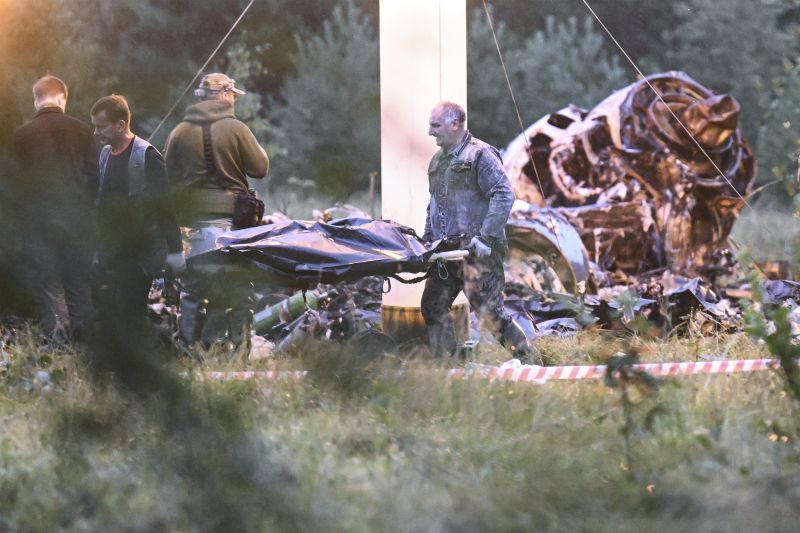 People carry a body bag away from the wreckage of a crashed private jet, near the village of Kuzhenkino, Tver region, Russia, Thursday. Russian mercenary leader Yevgeny Prigozhin, the founder of the Wagner Group, reportedly died when a private jet he was said to be on crashed on Wednesday, killing all 10 people on board.