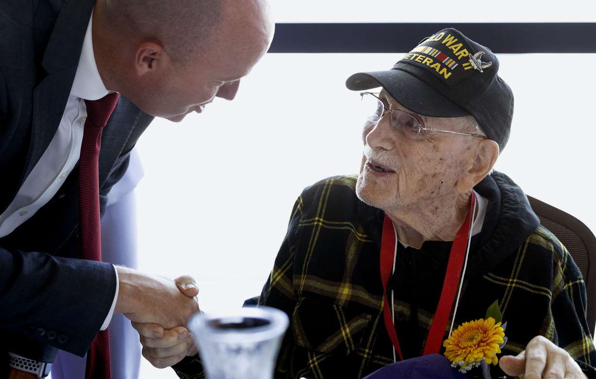Gov. Spencer Cox speaks with World War II veteran and 103-year-old Eugene Hecker at the Utah Department of Health and Human Services Division of Aging and Adult Services 35th annual centenarian celebration in West Jordan on Thursday.