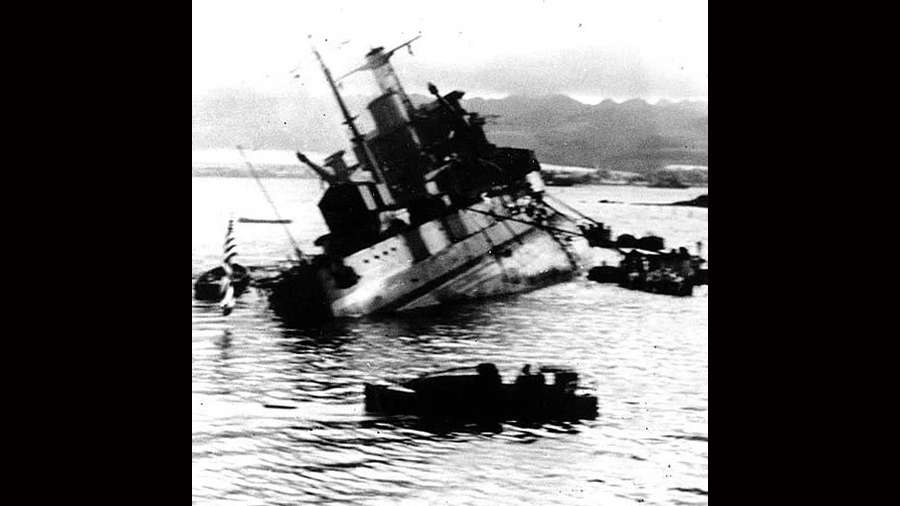 The last minutes of the USS Utah before it capsized, as photographed before the USS Tangier, moored behind the Utah.