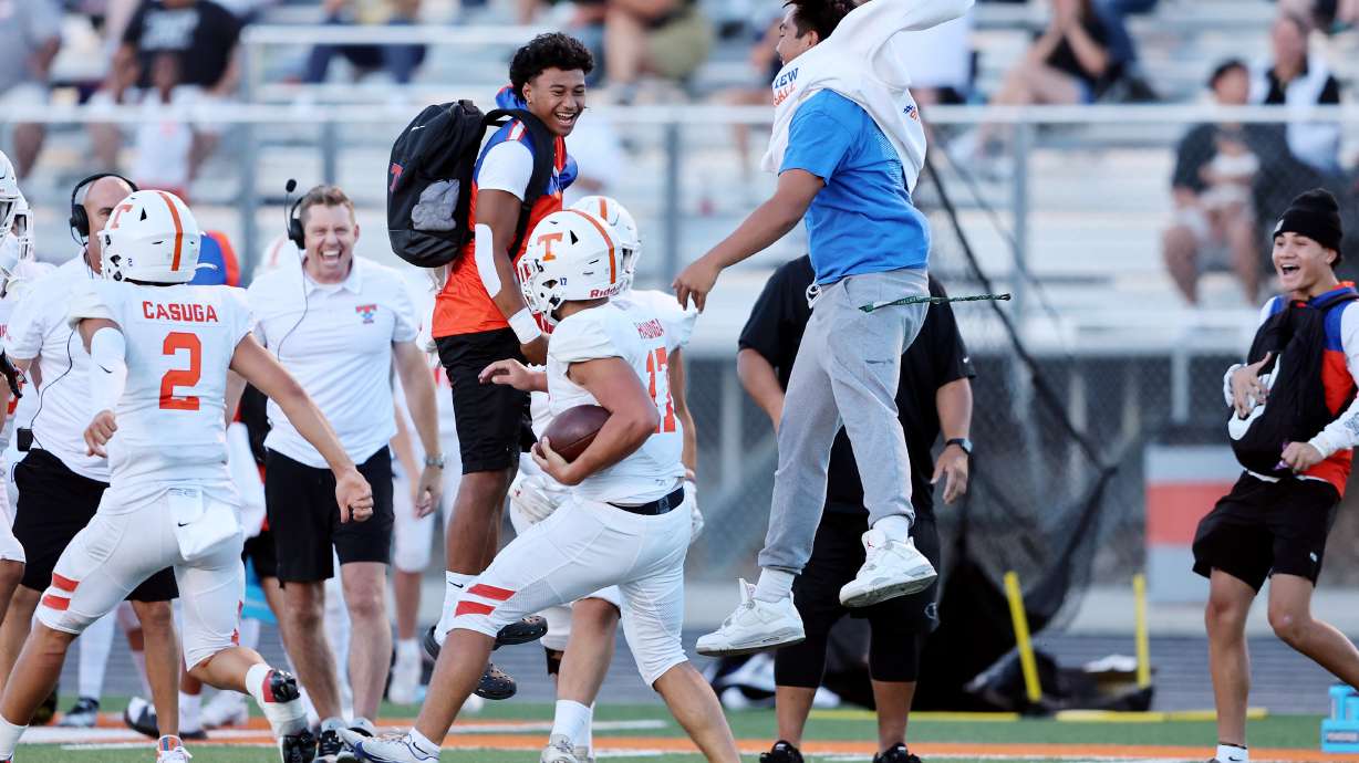 Timpview's Helaman Casuga (2) and Paka Haunga celebrate a big play on the sideline against Skyridge in Lehi on Friday, Aug. 11, 2023. Skyridge won 26-14.