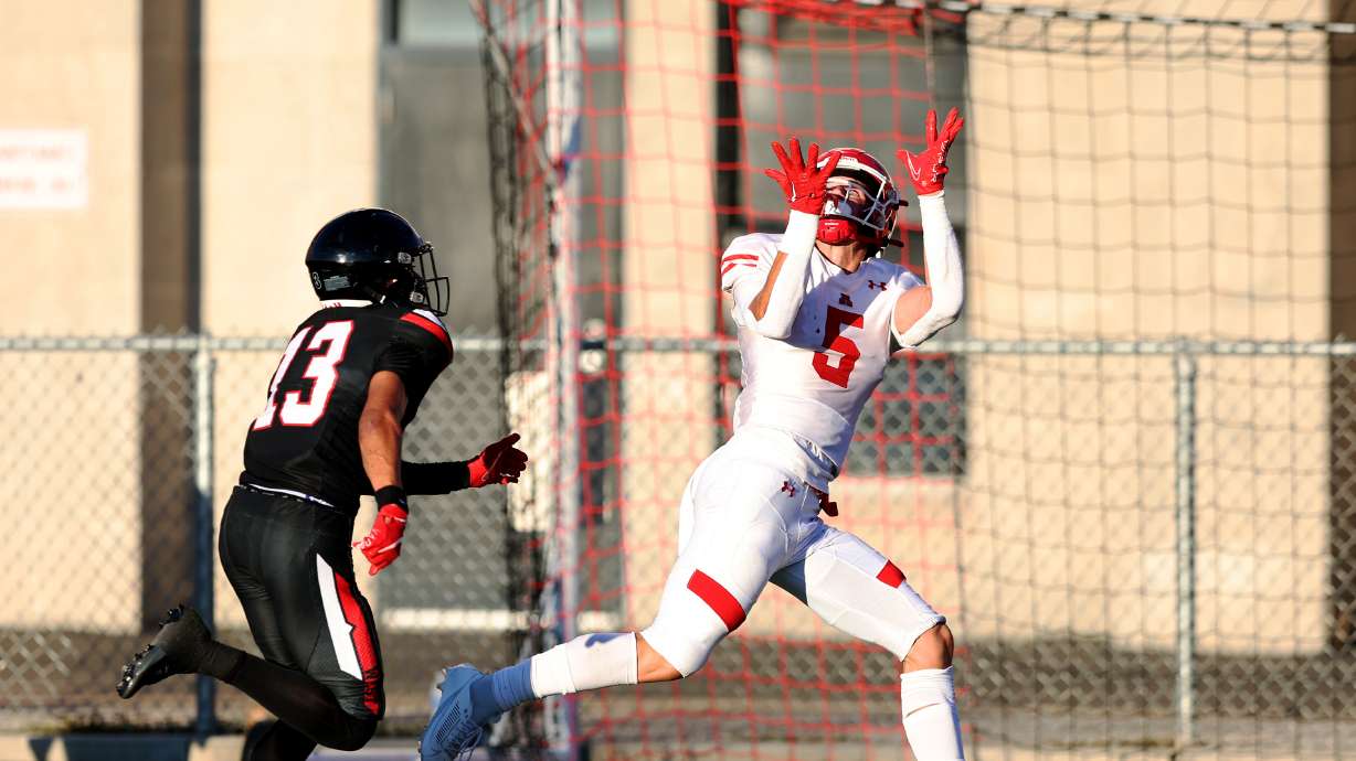 American Fork’s Davis Andrews reaches up for a long pass and touchdown ahead of West’s Lava Vailahi as the two teams play in Salt Lake City on Friday, Aug. 25, 2023. AF won 45-21.