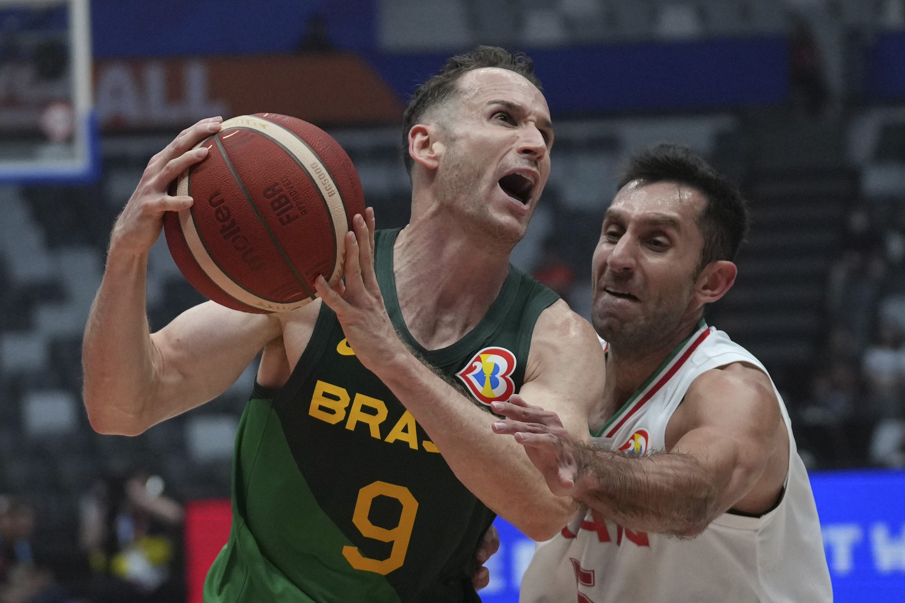 Brazil guard Marcelinho Huertas (9) drives past Iran guard Sajjad Mashayekhi (5) during the Basketball World Cup group G match between Iran and Brazil at the Indonesia Arena stadium in Jakarta, Indonesia Saturday, July 26, 2023. 
