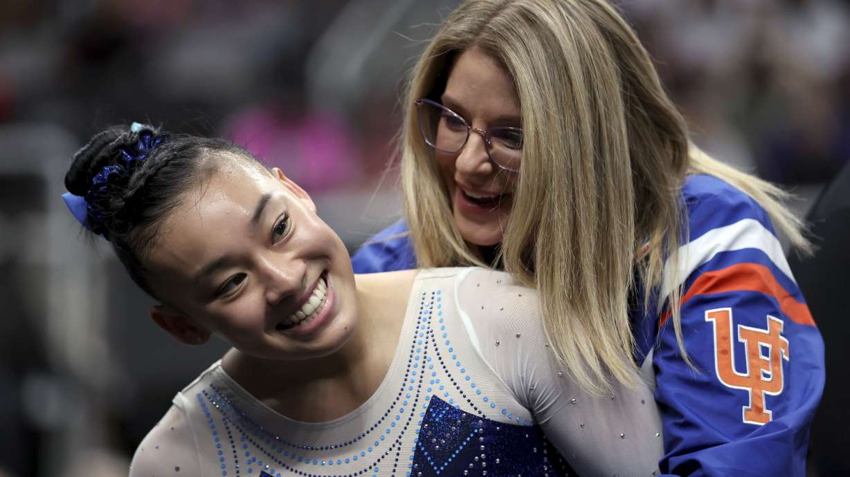 Leanne Wong, left, is congratulated by her coach Jenny Rowland, right, after competing in the floor exercise at the U.S. Gymnastics Championships, Friday, Aug. 25, 2023, in San Jose, Calif.