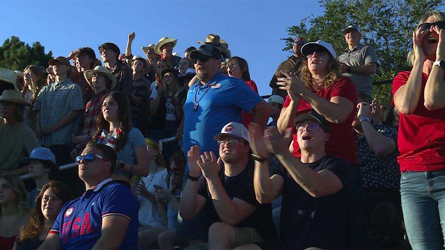 Kami Parker (center right, in red), with two of her sons sitting in front of her, cheers on her boys Jarom and Johnny at the Davis High vs. Clearfield High football game Friday, less than a week after her husband and their father died.