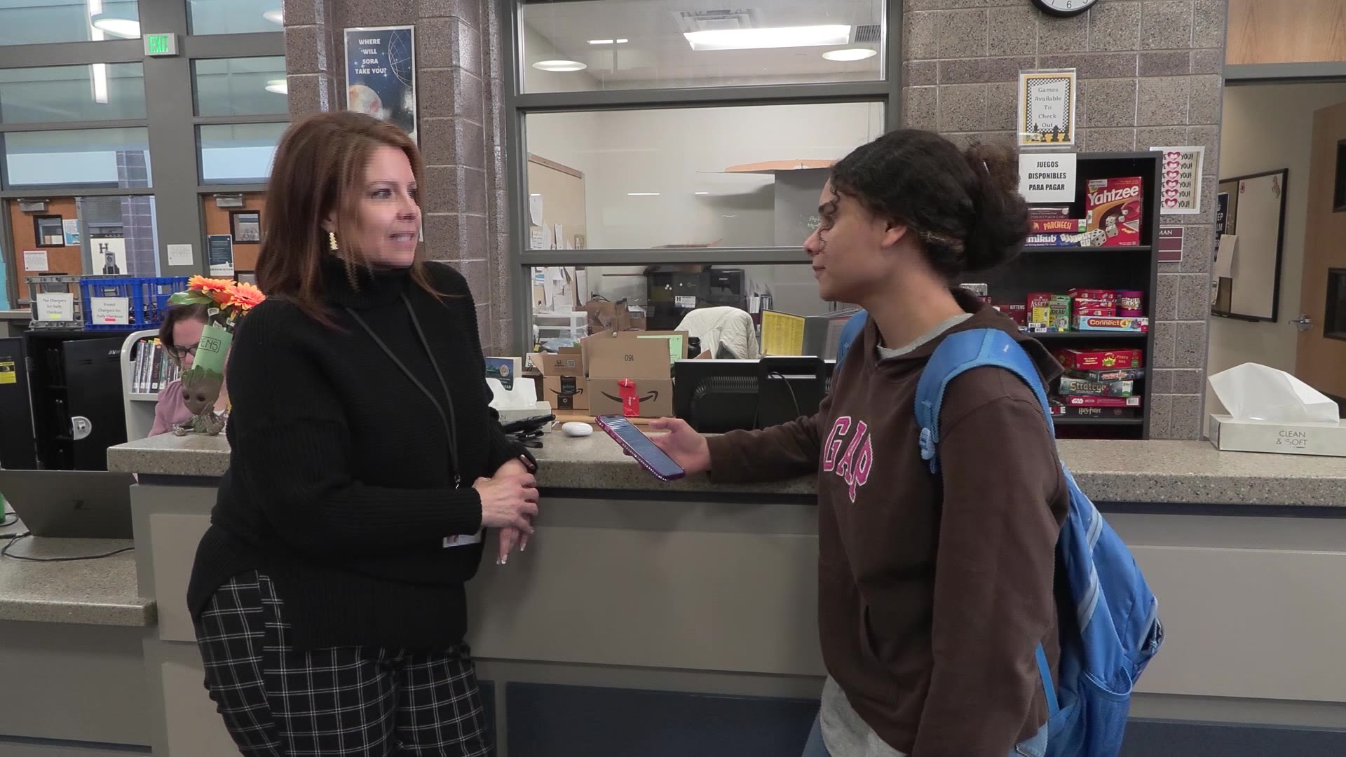 Rianyelis, right, and her teacher communicating with the help of the earbuds.
