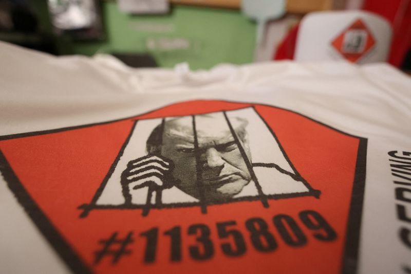 T-shirts and hats with an image depicting the mugshot of former President Donald Trump are pictured at the Y-Que printing store in Los Angeles, Friday.
