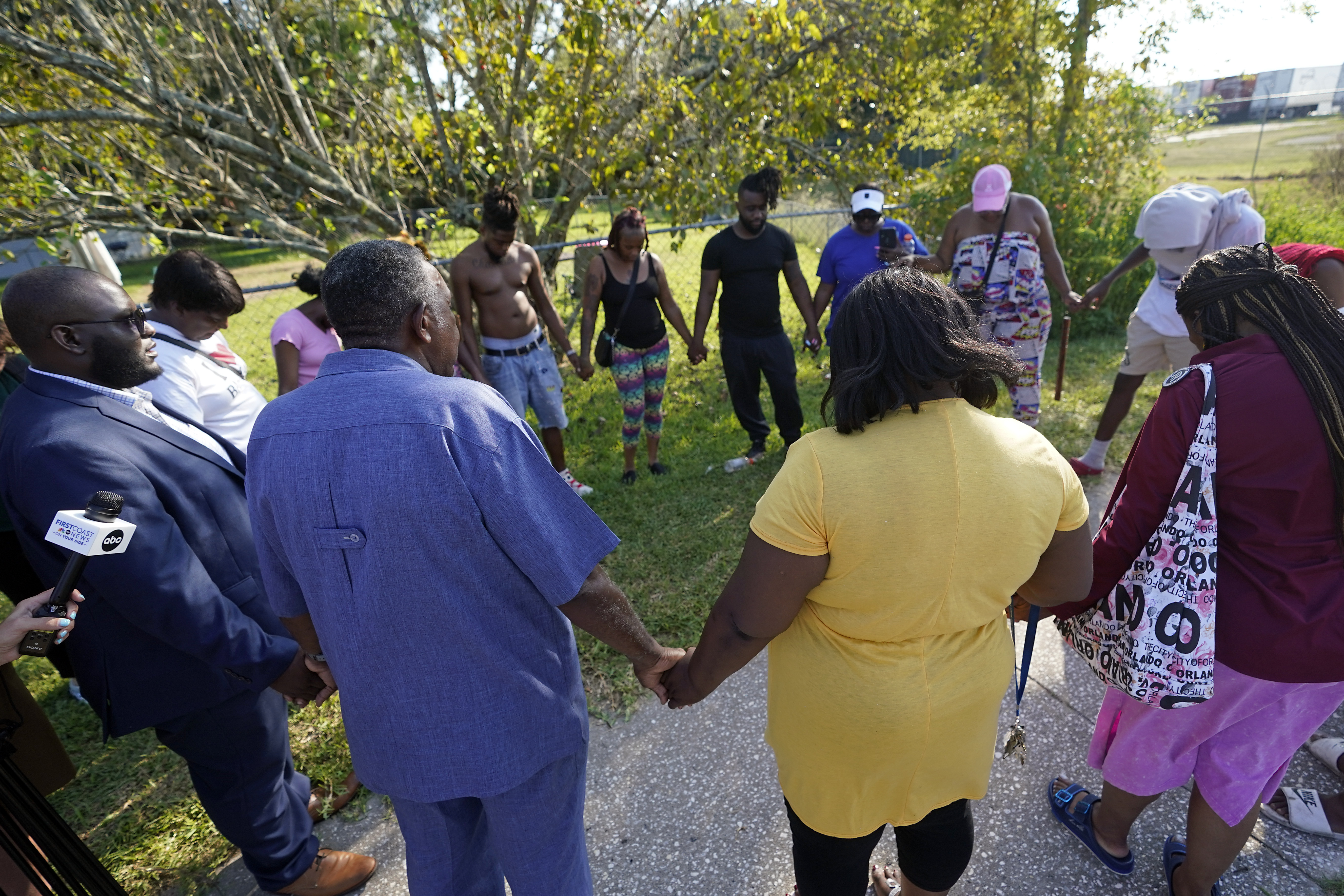 Residents gather for a prayer near the scene of a mass shooting at a Dollar General store, Saturday in Jacksonville, Fla. A 21-year-old white man fatally shot three Black people in Florida, the local sheriff said. 