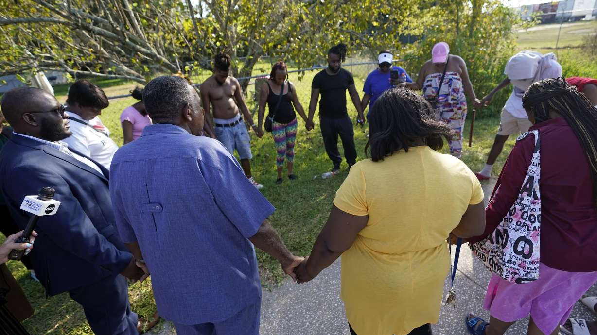 Residents gather for a prayer near the scene of a mass shooting at a Dollar General store, Saturday in Jacksonville, Fla. A 21-year-old white man fatally shot three Black people in Florida, the local sheriff said.