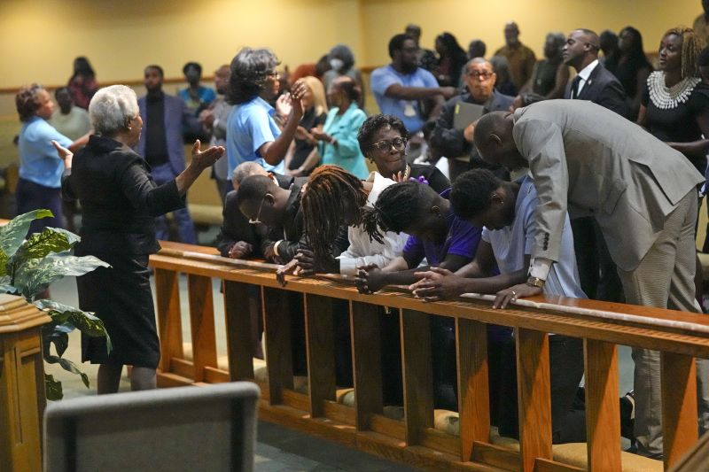 Church members at the St. Paul A.M.E. Church pray with four Edward Waters University students, center, that attended a prayer service for the victims of a mass shooting, Sunday in Jacksonville, Fla.