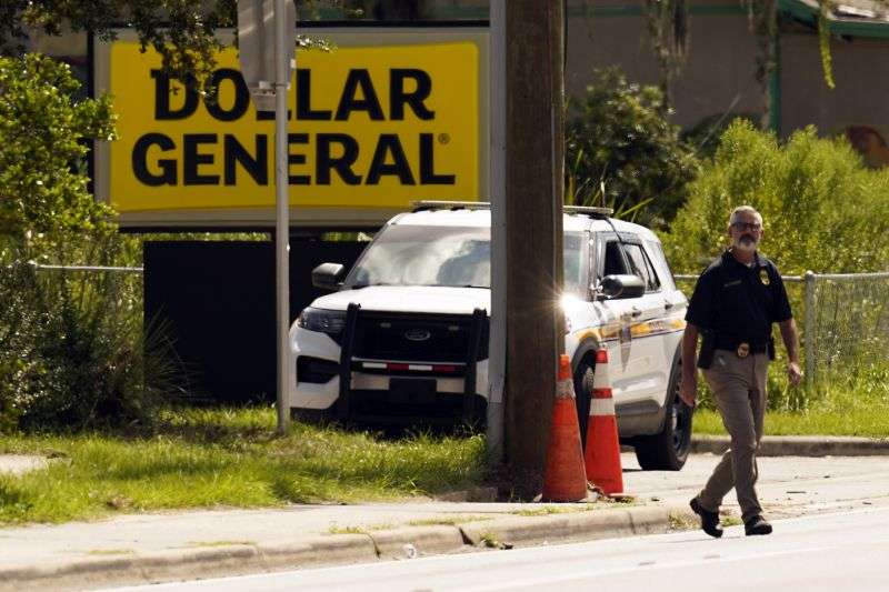 Law enforcement officials continue their investigation at a Dollar General Store that was the scene of a mass shooting, Sunday in Jacksonville, Fla.