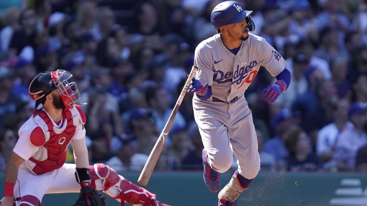 Los Angeles Dodgers' Mookie Betts, right, watches the flight of his two-run home run as Boston Red Sox catcher Connor Wong, left, looks on in the sixth inning of a baseball game, Sunday, Aug. 27, 2023, in Boston.