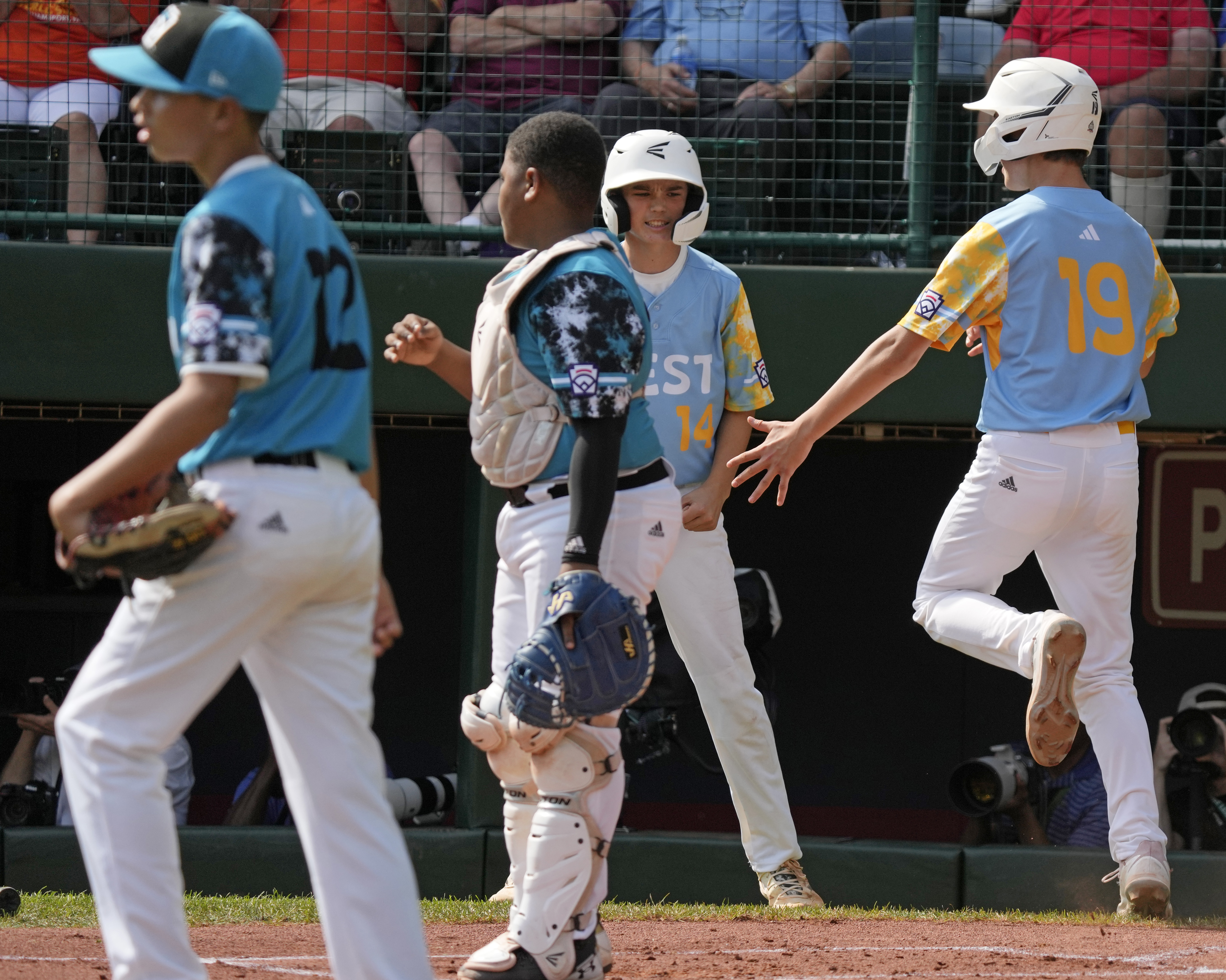 El Segundo, Calif.'s Louis Lappe (19) and celebrate after scoring on a double by Lucas Keldorf off Curacao's Sean Serverie (12) during the first inning of the Little League World Series Championship game in South Williamsport, Pa., Sunday, Aug. 27, 2023. 