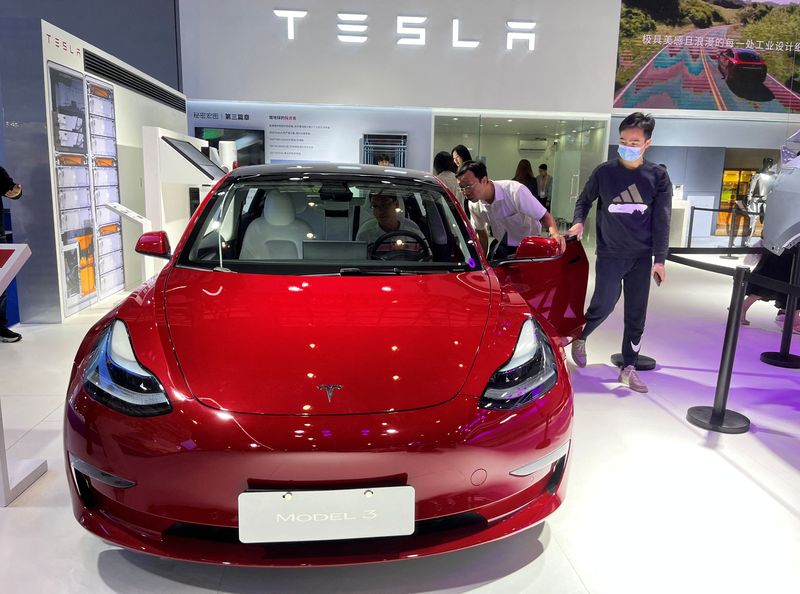 Visitors look at a Tesla Model 3 electric vehicle at the third China International Consumer Products Expo, in Haikou, Hainan province, China, April 12. Tesla is set to defend itself for the first time at trial against allegations that its Autopilot driver assistant feature led to a fatality.