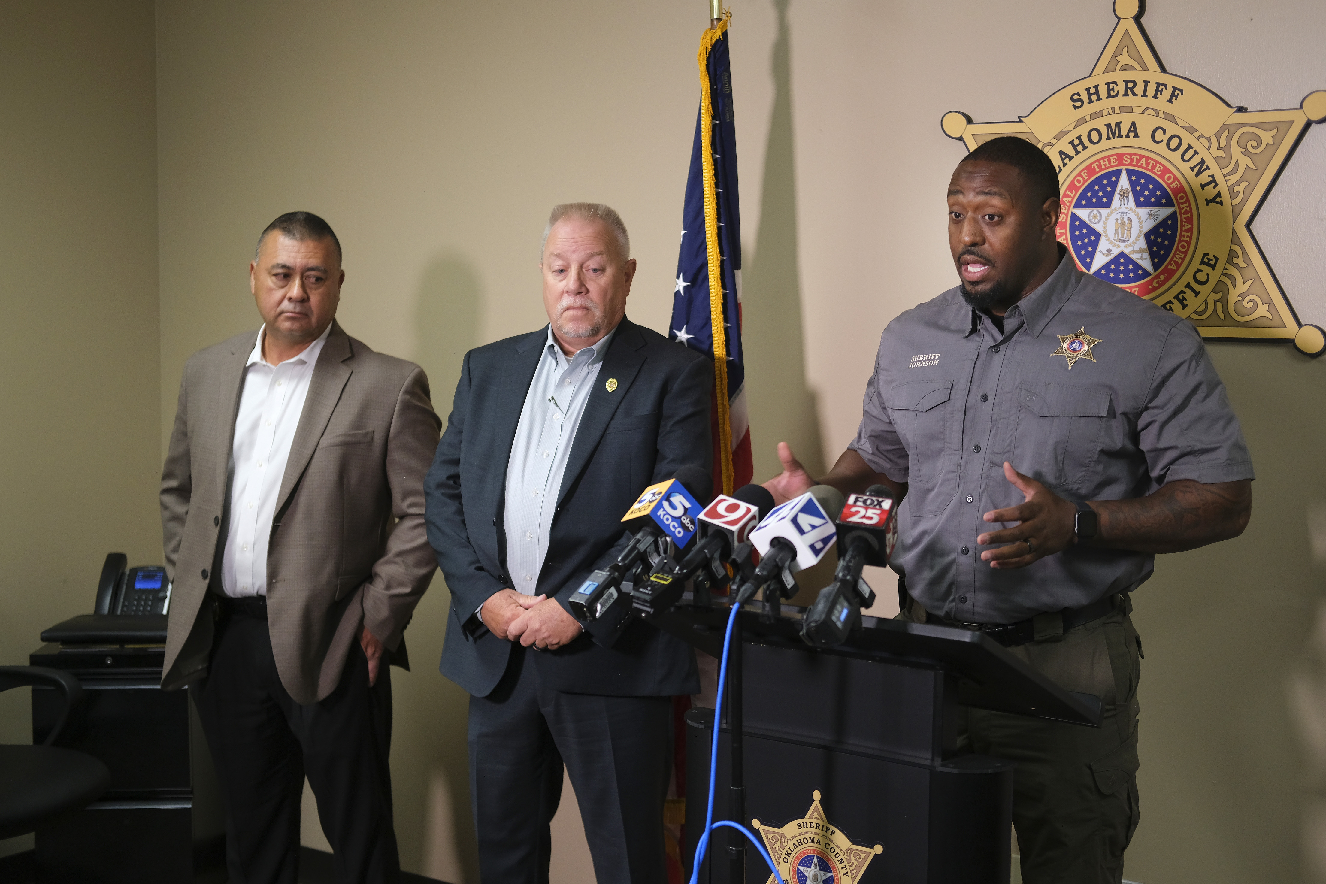 Oklahoma County Sheriff Tommie Johnson III, right, addresses the media in Oklahoma City, Monday, Aug. 28, 2023, alongside Del City Assistant Police Chief Austin Slayten, left, and Del City Police Chief Lloyd Berger, center, during a news conference about the shooting incident at the Del City-Choctaw high school football game on Friday night, Aug. 25.