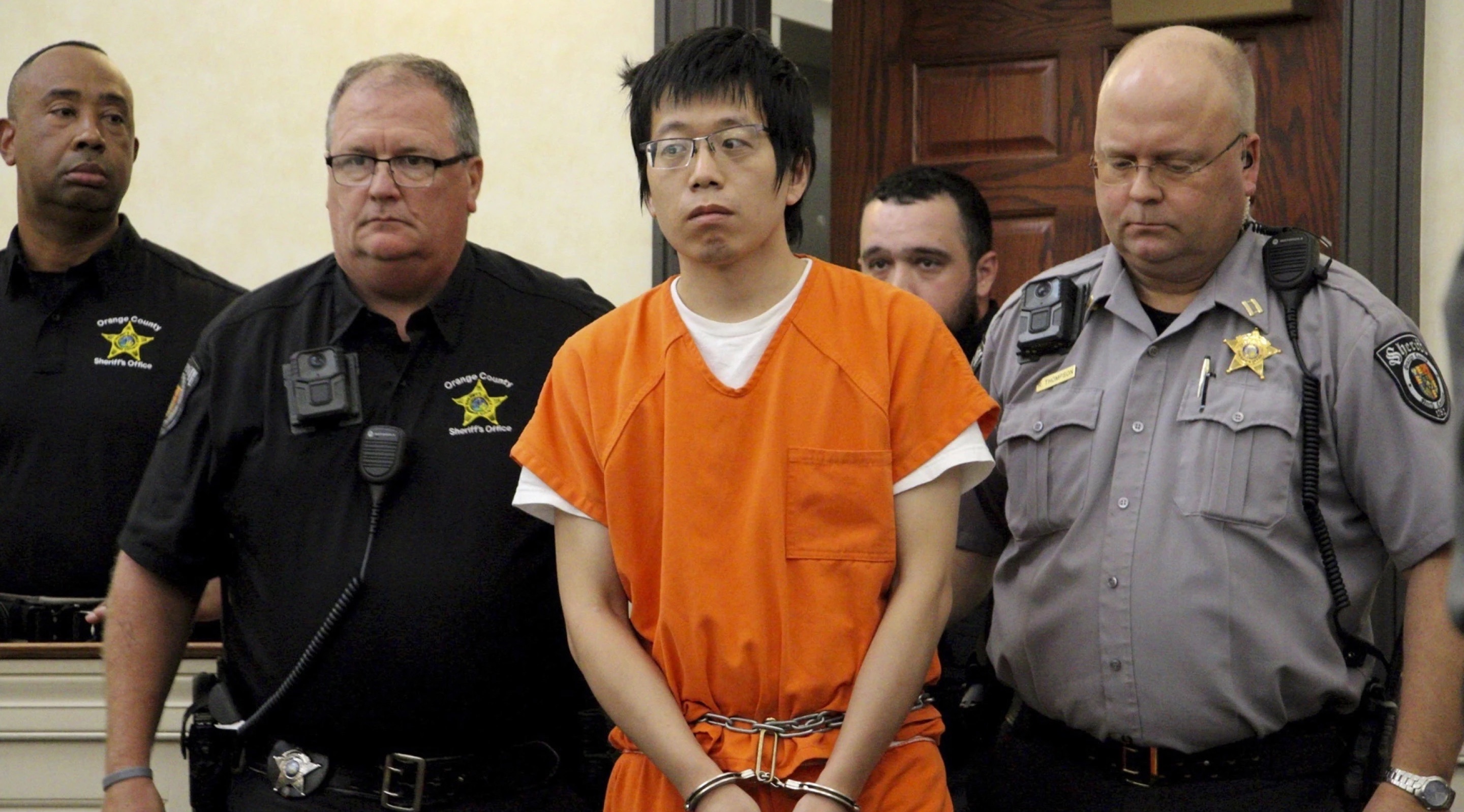 Tailei Qi, the graduate student suspected in the fatal shooting of a University of North Carolina at Chapel Hill faculty member, center, made his first appearance at the Orange County Courthouse in Hillsborough, N.C., Tuesday.