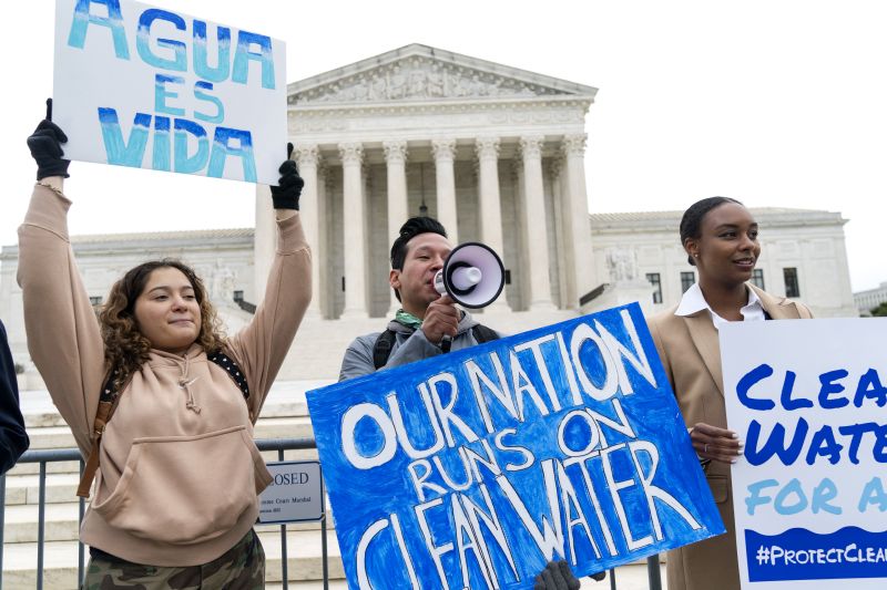 Bethsaida Sigaran, left, of Baltimore, her brother Jaime Sigaran, with American Rivers, and Thea Louis, with Clean Water Action, join supporters of the Clean Water Act as they demonstrate outside the Supreme Court, Oct. 3, 2022, in Washington.