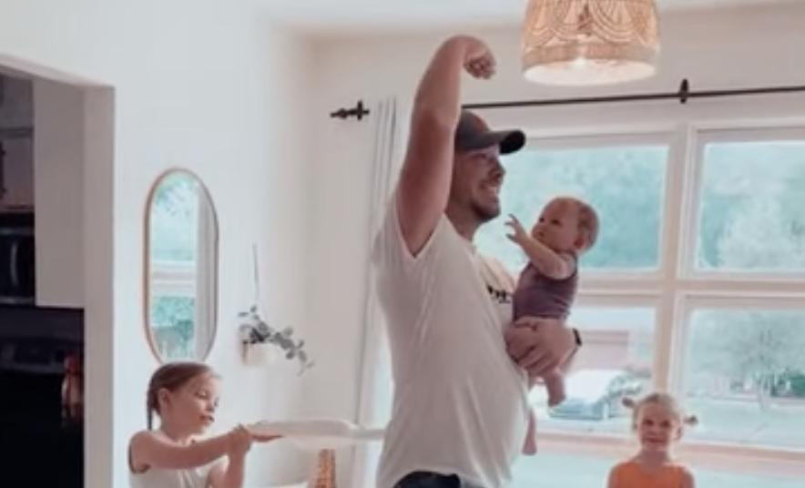 A dad plays with his three daughters as they pretend to wind him up like a dancing ballerina.