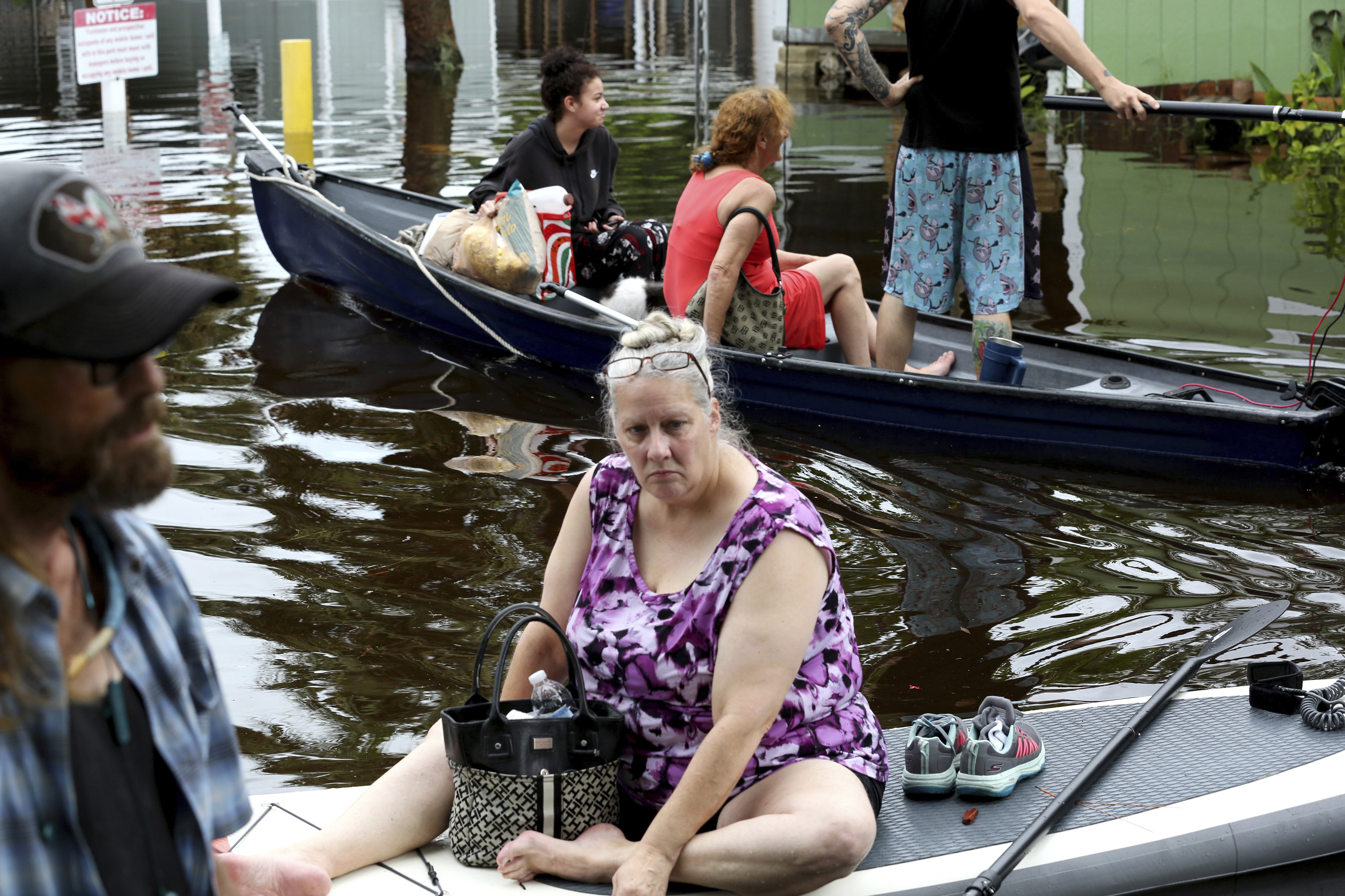 Residents of Twin City Mobile Home Park, a manufactured home community in flood zone A, navigate through the neighborhood in high waters, Wednesday in St. Petersburg, Fla. Hurricane Idalia made landfall in the lightly populated Big Bend region, where the Florida Panhandle curves into the peninsula.