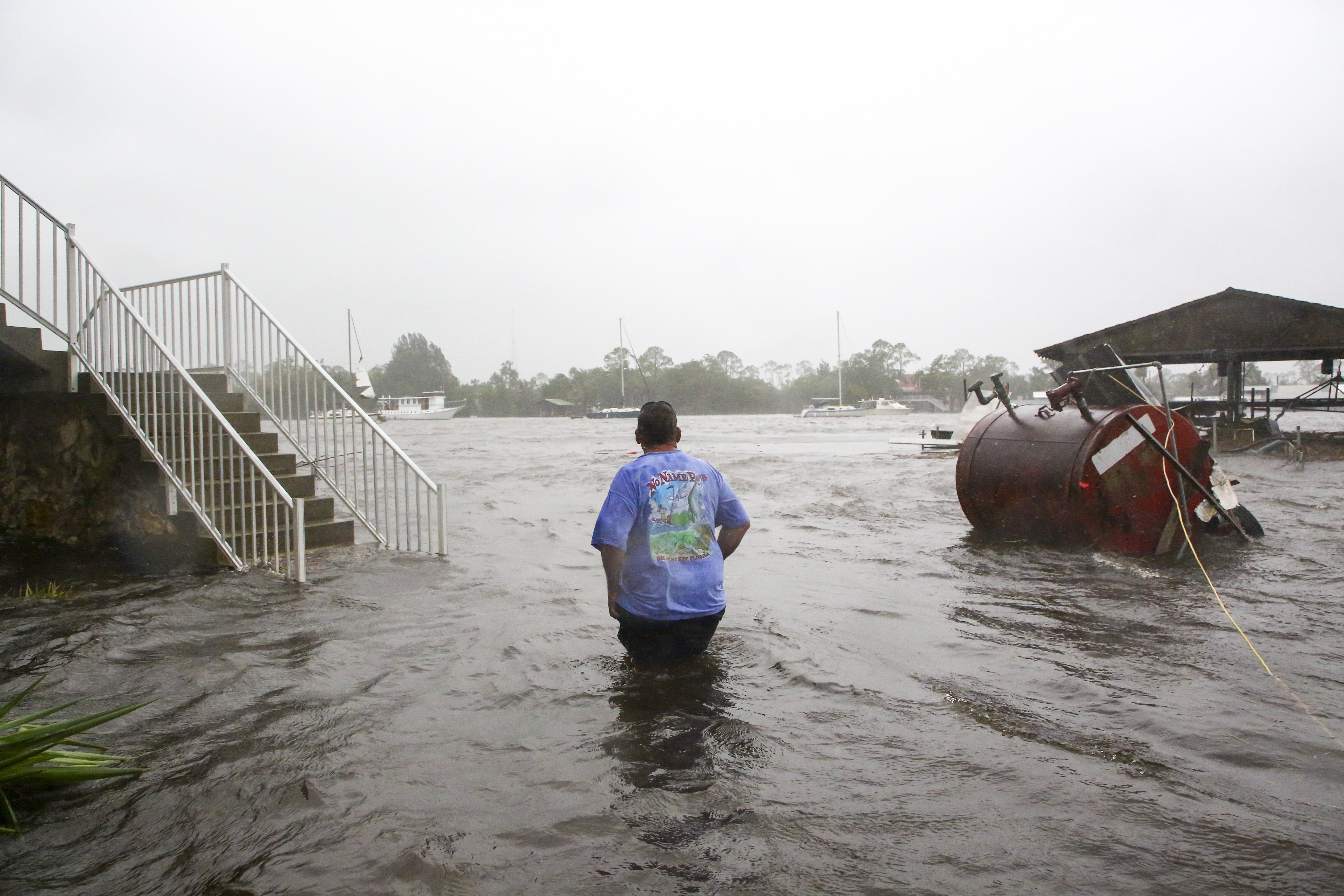 Daniel Dickert wades through water after the Steinhatchee River flooded on Wednesday in Steinhatchee, Florida, after the arrival of Hurricane Idalia.