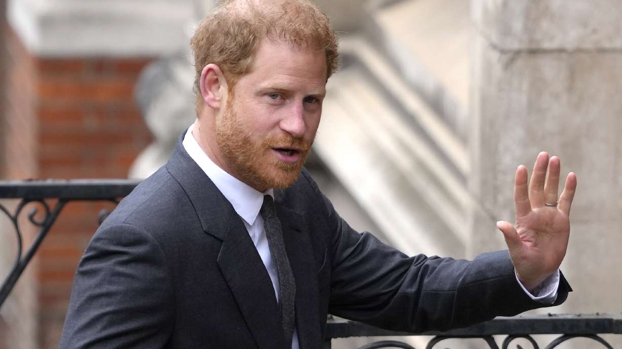 FILE - Britain's Prince Harry salutes media as he arrives at the Royal Courts of Justice in London, on March 30, 2023. Prince Harry is expected to return to the U.K. next month to attend a charity awards ceremony on the eve of the first anniversary of Queen Elizabeth II’s death.