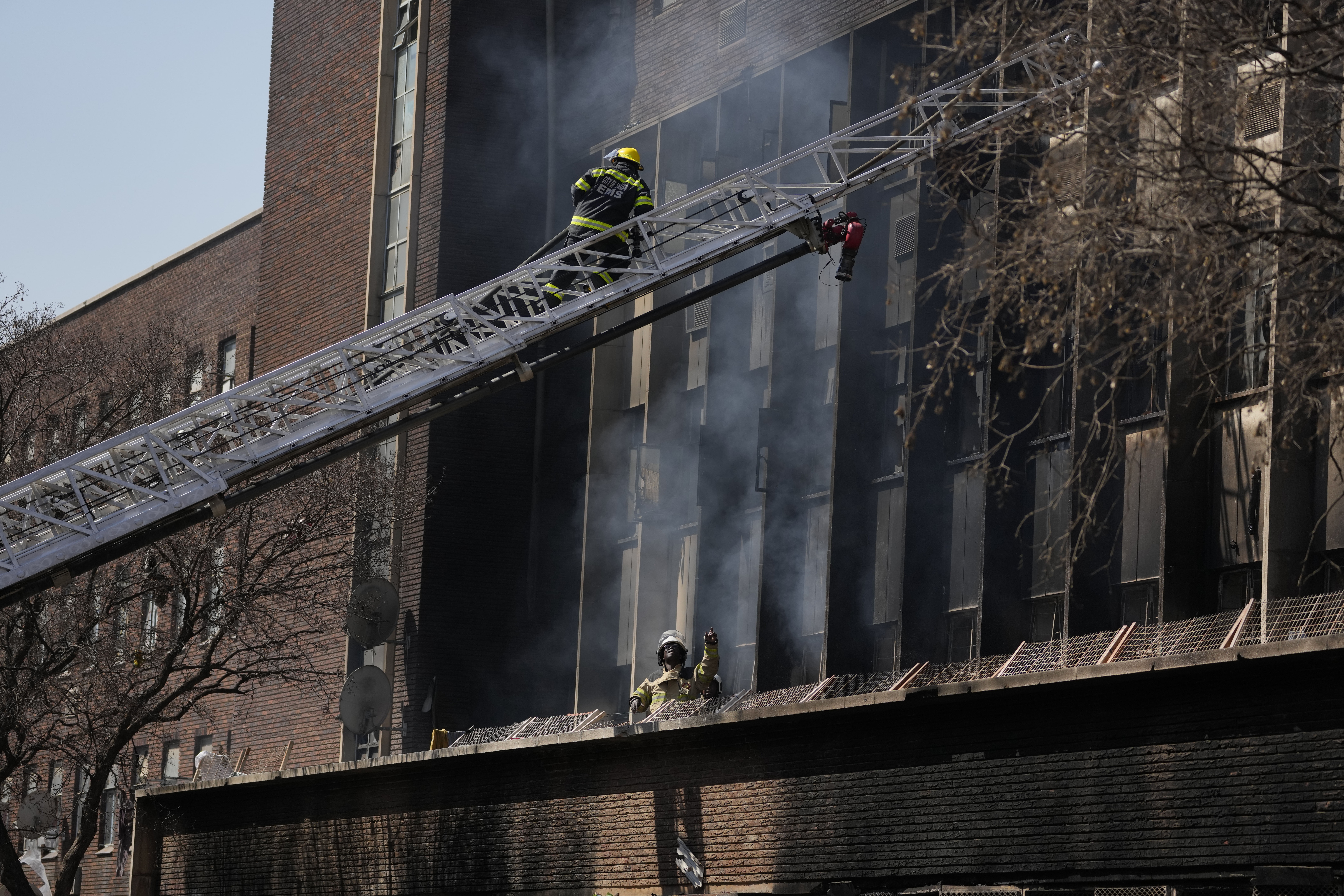 Fire Marshals inspect the scene of a deadly blaze in downtown Johannesburg, Thursday. Dozens died when a fire ripped through a multi-story building.