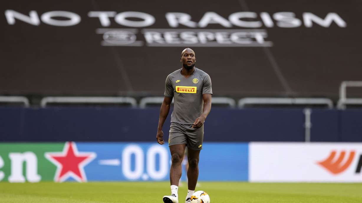 FILE - Inter Milan's Romelu Lukaku walks on the pitch in front of a 'no to racism' banner during the training session prior the Europa League round of 16 soccer match between Inter Milan and Getafe at the Veltins-Arena in Gelsenkirchen, Germany, Tuesday, Aug. 4, 2020. U.N.-backed human rights experts focusing on racial discrimination called on Italy's government to do more to eliminate acts of violence, hate speech, stigmatization and harassment against Africans and people of African descent, and expressed concern that no legal cases have been brought to punish fans and others racist acts at sports events.