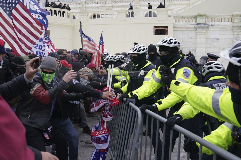 Rioters loyal to President Donald Trump clash with police at the U.S. Capitol on Jan. 6, 2021, in Washington. Liberal groups are trying to end Trump's attempt to return to the White House by arguing that he is no longer eligible to be president after trying to overturn the 2020 election results.