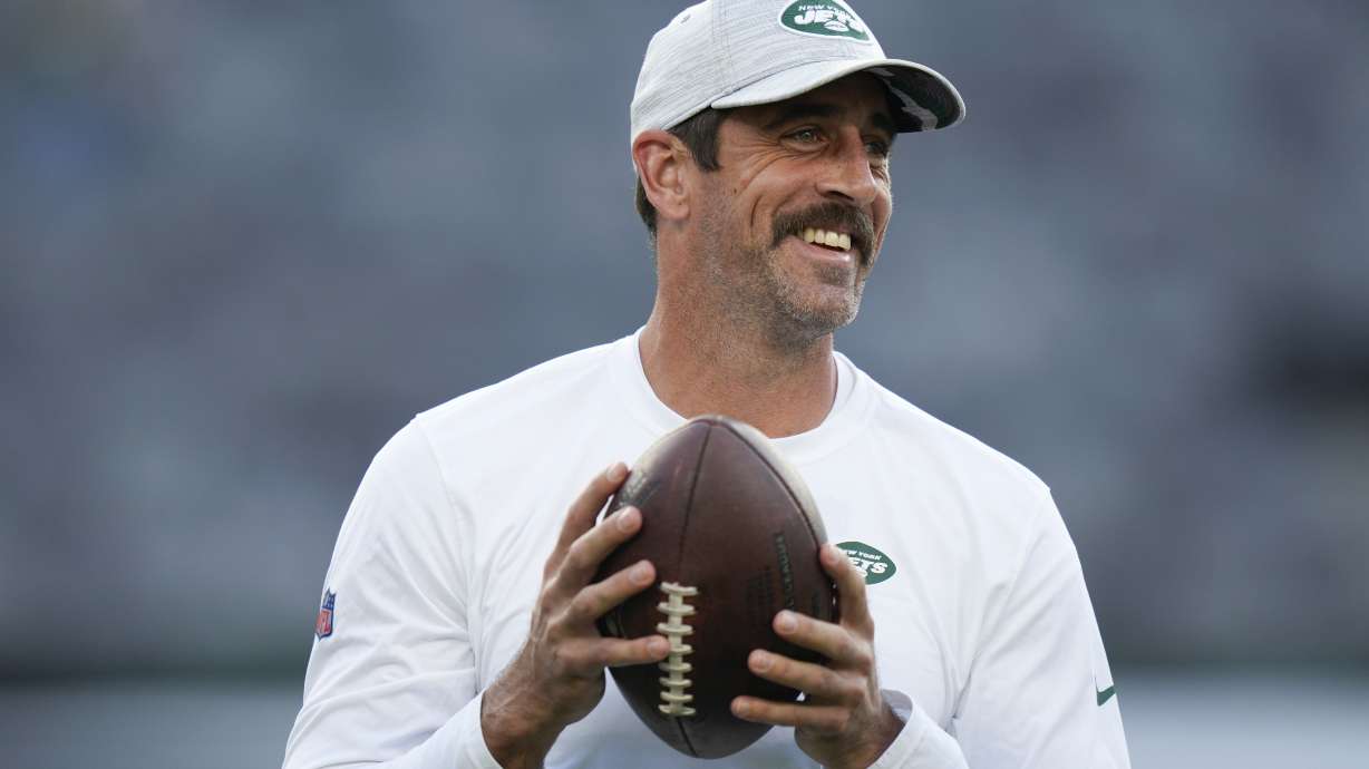 FILE - New York Jets quarterback Aaron Rodgers walks on the field during warm-ups before an NFL football game against the Tampa Bay Buccaneers, Saturday, Aug. 19, 2023, in East Rutherford, N.J. He’ll become a folk hero if he can lead the Jets to a Super Bowl for the first time since Broadway Joe Namath.