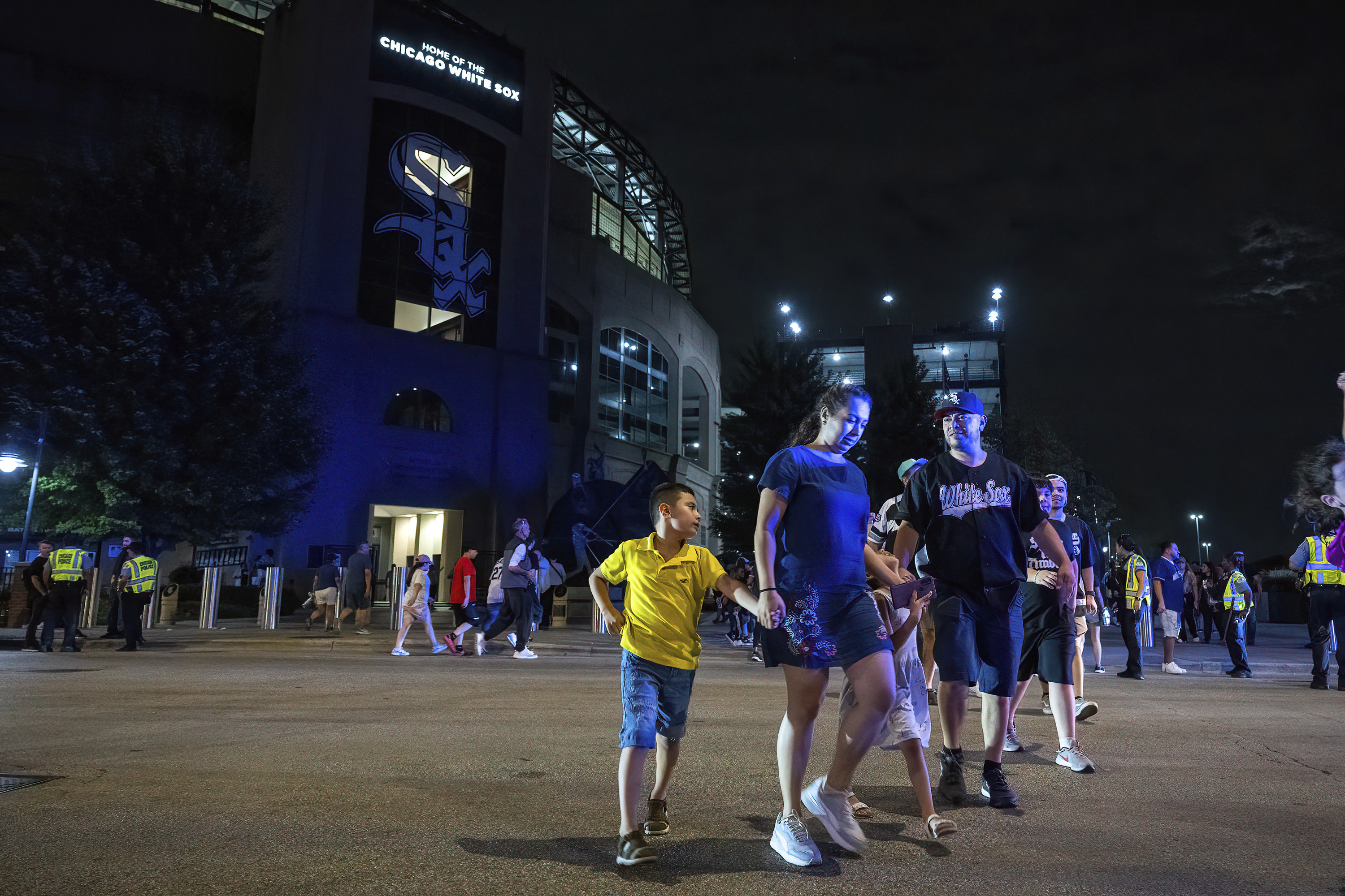 Fans leave the ballpark as police respond to a shooting that took place at Guaranteed Rate Field on Friday, Aug. 25, 2023, in Chicago. Police are investigating a shooting at a White Sox baseball game at the stadium Friday night. Police said the investigation is ongoing. 
