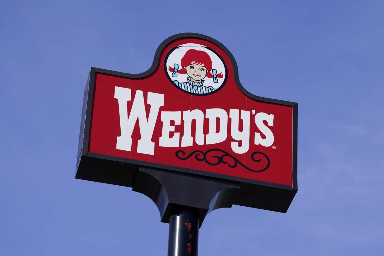 A sign stands over a Wendy's restaurant, Feb. 25, 2021, in Des Moines, Iowa. Some consumers say those mouthwatering ads can cross the line into deception, and that’s leading to a growing number of lawsuits.