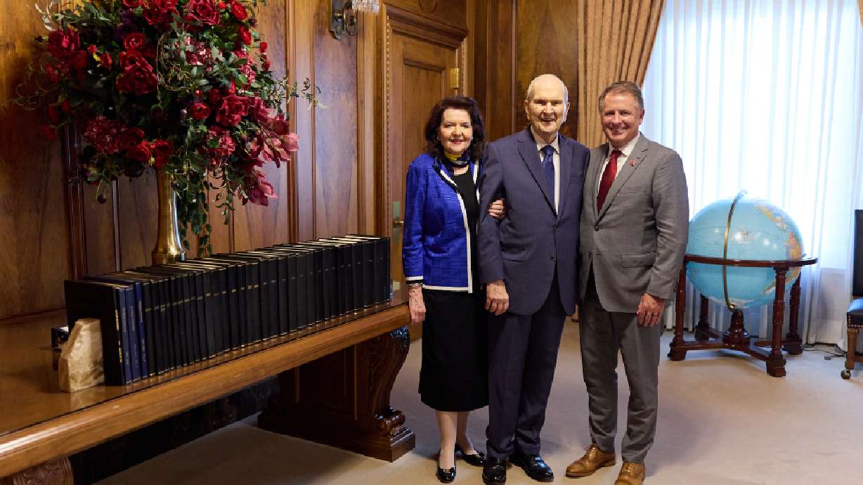President Russell M. Nelson, center, his wife Wendy, and University of Utah President Taylor Randall stand near the church president's medical journals at the Church Administration Building in Salt Lake City on Wednesday.